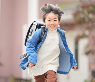 黒のランドセルを背負って走る男の子